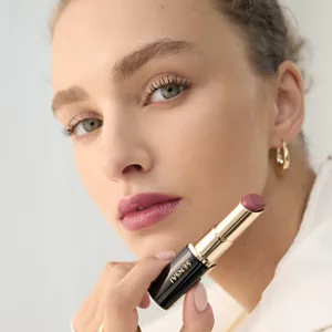 Person holding Lasting Plump Lipstick in their hand after applying product on lips